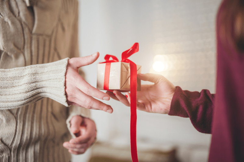 One person handing a gift to another