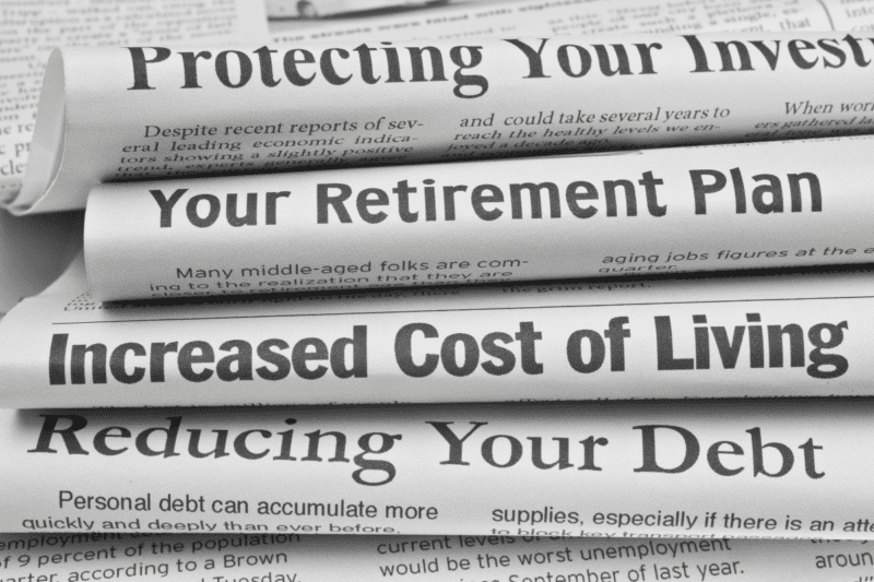Stacked newspapers showing various headlines.